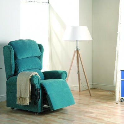 The C-Air chair from Repose Furniture in a living room environment, with side table and lamp.
