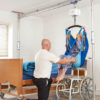 The Prism Pressure Fit Gantry is used with a hoist and sling to lift a woman.