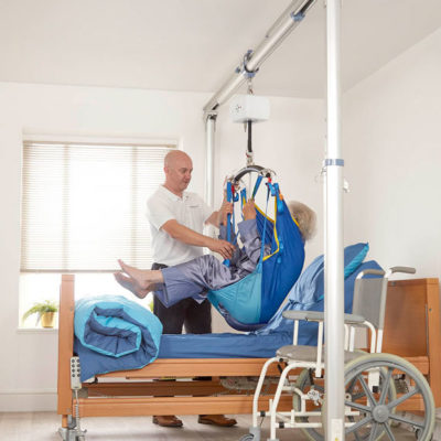 The Prism FSG Free Standing Gantry and a hoist being used to lift a patient in a sling.